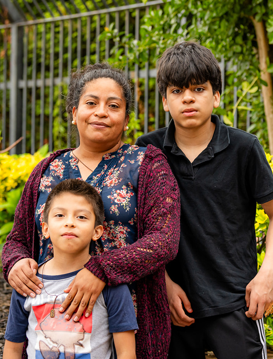 Mother standing in front of park with her son and daughter