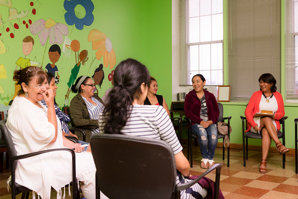a group of women sitting in a circle having a conversation