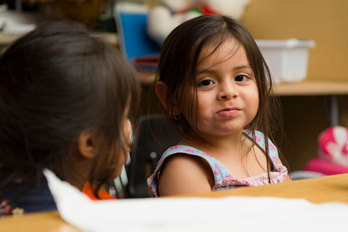 a little girl sitting at a table